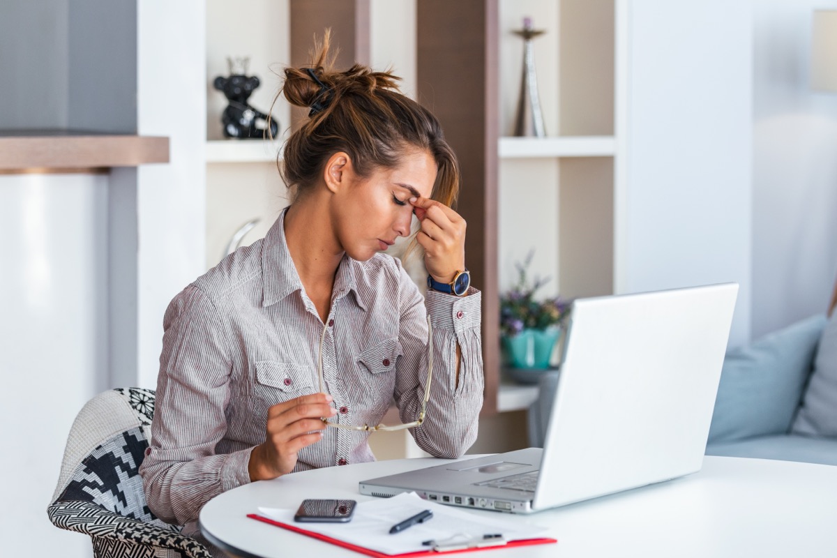 femme avec céphalée de tension assise au bureau